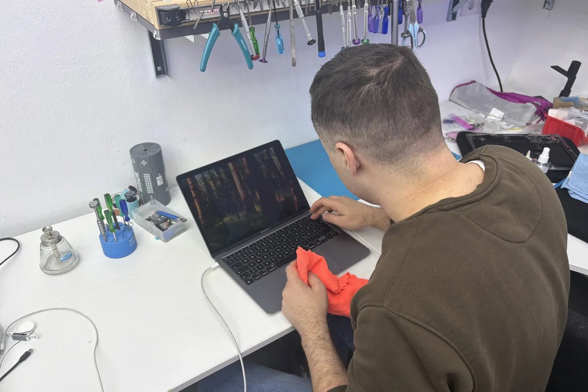 MacBook mit abgenommenem Display auf einem Reparaturtisch